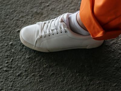 Top view of sneakers on a dark textured floor.